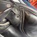 Close-up of a leather saddle with a visible brand label.